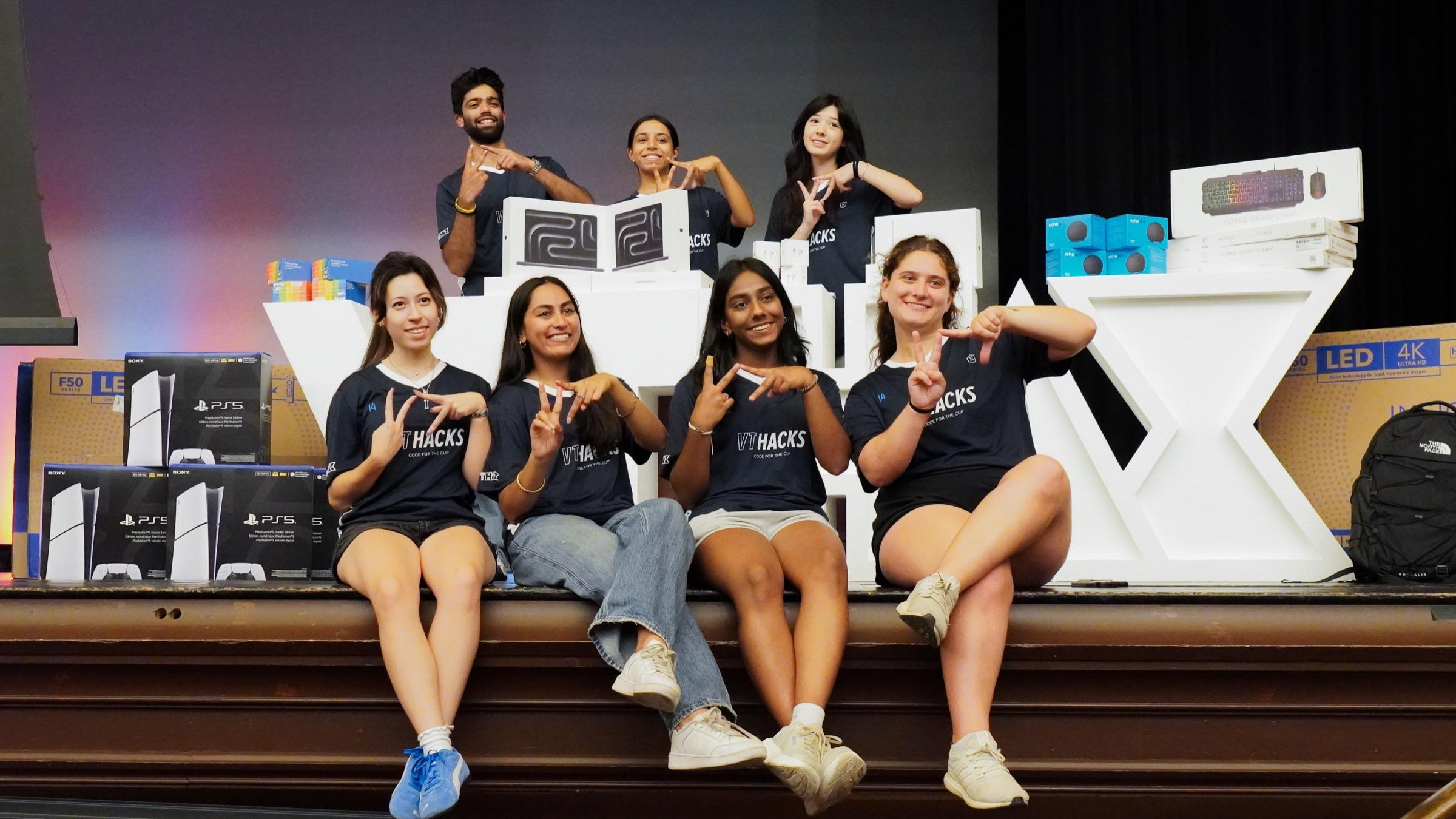 VTHacks organizers posing on stage with the event prizes